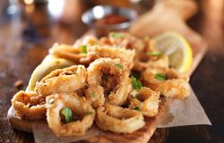 Fried calamari with lemon wedges and herbs